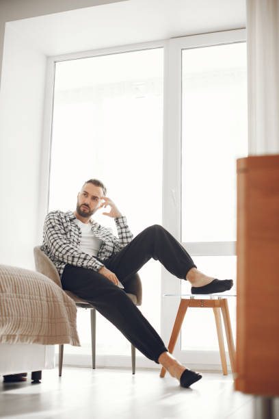 istock Attractive smart man sitting in the living room 1303758565