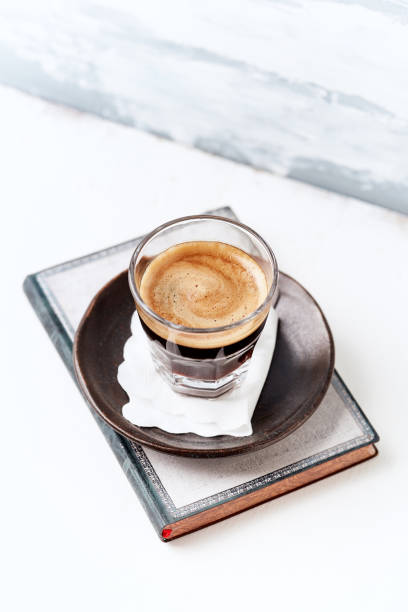 istock Coffee in glass cup on bright wooden background. 1303758703