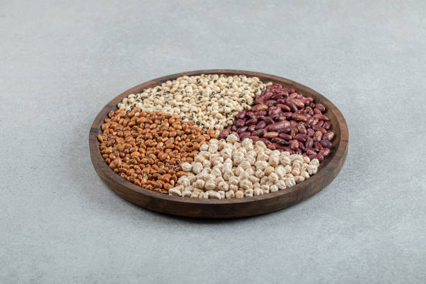 istock Plate of various dry pea and beans on marble surface 1303759244