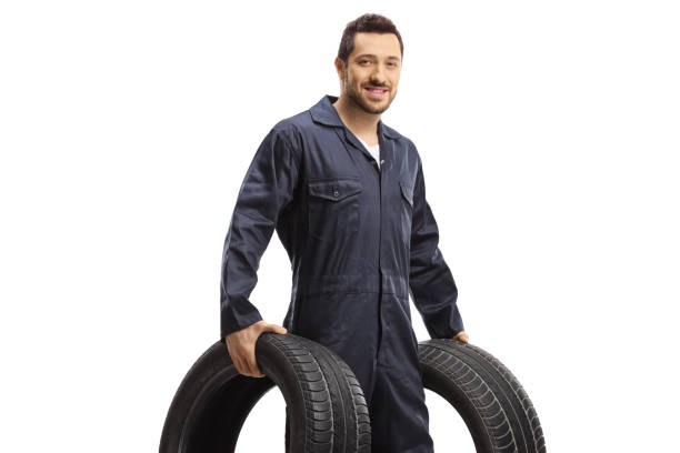 istock Mechanic holding two vehicle tires 1303760945