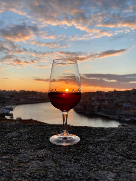 бокал красного вина на смотровой площадке порту на закате с видом - barware стоковые фото и изображения