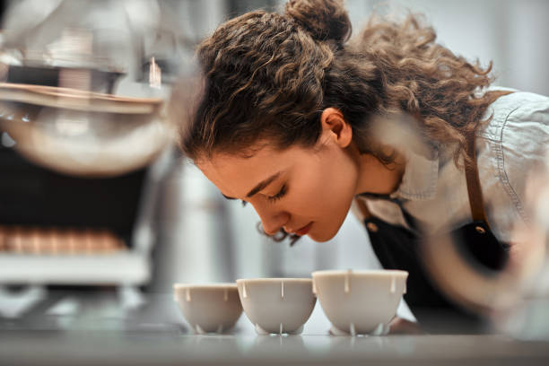 selektiver fokus von coffee-shop-mitarbeitern, die die kaffeequalität während der kaffee-food-funktion überprüfen. seitenansicht. nahansicht. - tasting stock-fotos und bilder