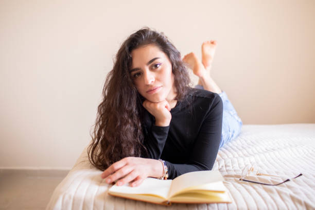 istock Young woman studying in bed 1303763144