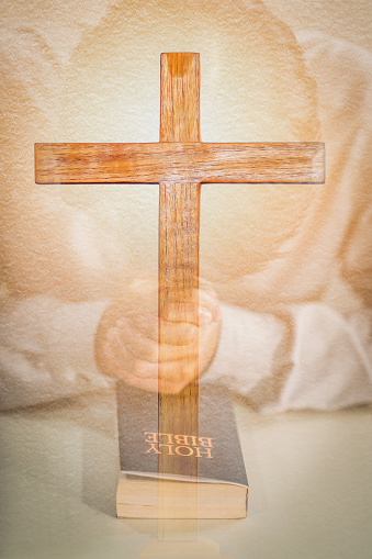 double exposure christianity background of holy bible on table in chruch and man praying for god blessing overlay with wooden cross