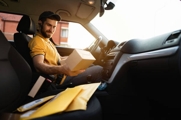 istock Young courier holding and looking at the package 1303770273