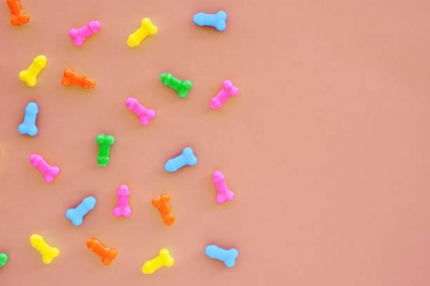 istock multi-colored sweets in the form of penises on a light background. copy space. 1303774204