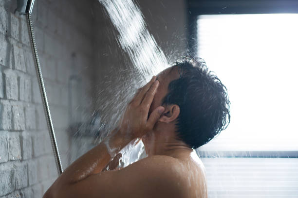 Handsome asian guy Taking a shower in the bathroom stock photo