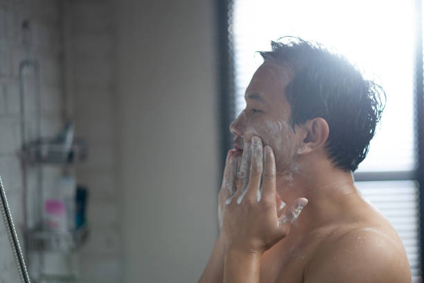 istock handsome Asian man taking a shower and using a facial foam 1303774346