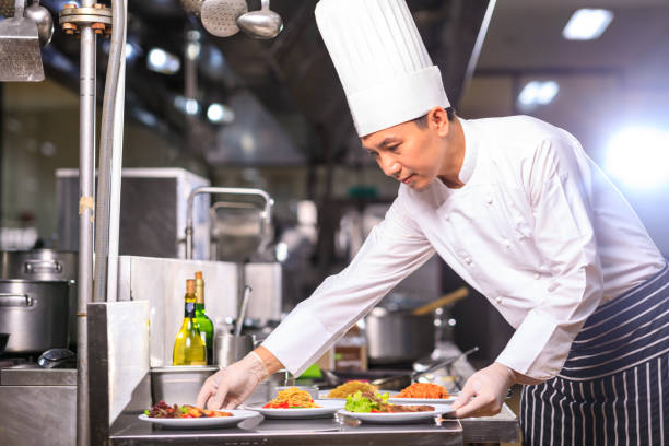 istock Asian Male chef presenting the dish in the kitchen. Selective focus. 1303774861