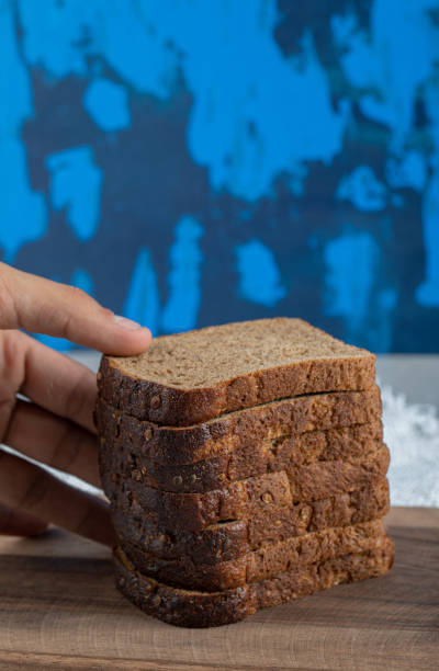 istock Hand holding a slices of brown bread 1303775651