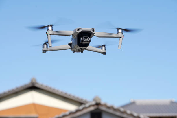 Drone flying near a private house Kagawa, Japan - Feb 6, 2021: Flying radio controlled DJI Mavic air2 quadcopter drone with aerial photo and video camera against the clear blue sky. drone point of view stock pictures, royalty-free photos & images