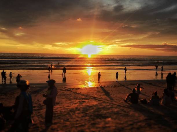 Sunset in Kuta, Bali Sunset in Kuta, Bali. Taken before the pandemic situation. People enjoy their time during the sunset. Picture taken by iphone 7, processed with Focos kuta beach stock pictures, royalty-free photos & images