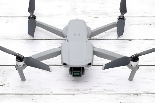 Kagawa, Japan - Feb 3, 2021: Close-up of drone quadrocopter DJI Mavic air2. New tool for aerial photo and video. White wooden table background.