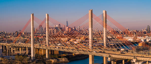 vista aérea del puente kosciuszko que rodea el distrito industrial de williamsburg, con la remota vista de manhattan en el telón de fondo, en la madrugada soleada mañana. panorama cosido de alta resolución extra grande. - brooklyn bridge new york city angle brooklyn fotografías e imágenes de stock