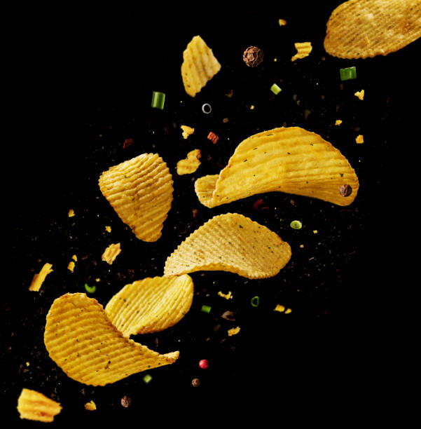 istock Flying potato chips with onions and peppers on a black background. 1303780807
