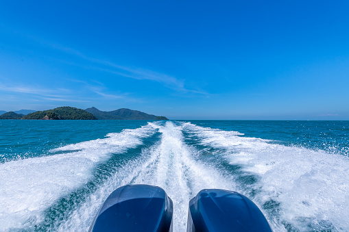 Speed motorboat engine speed fast to travel  island show white splash wave foam with blue sky background.