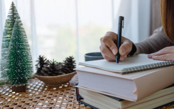 istock a beautiful young asian woman writing on notebook while study at home 1303783339