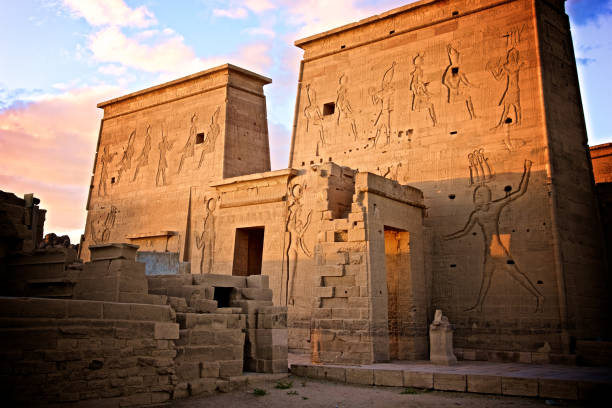 coucher du soleil au-dessus du mur égyptien de hiéroglyphes dans le temple de philae d’isis sur le nil en egypte - front view photos photos et images de collection
