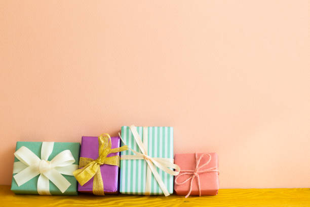 istock Colorful gift boxes on wooden table. pink background. copy space 1303788965