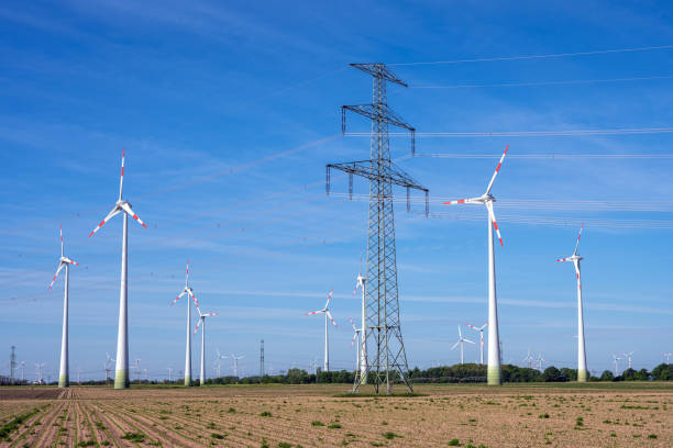 istock Electricity pylon and wind turbines 1303790893