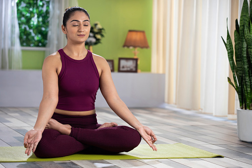 Beautiful attractive young woman doing yoga exercising at home