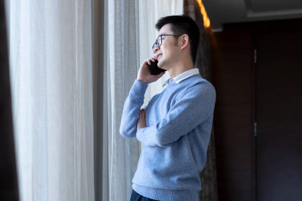 istock Asian man making a phone call while working at home 1303795271
