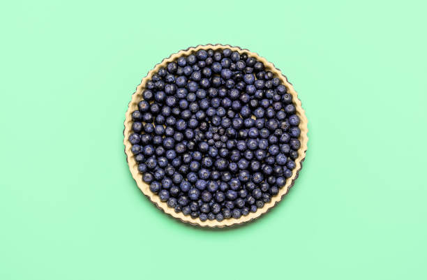 Blueberry pie, uncooked, isolated on colored background, top view. Baking pie at home