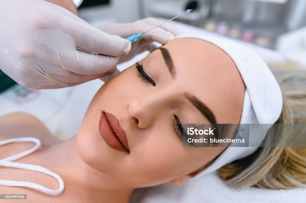 Mesotherapy facelifting procedure Thread face lift, using mesothreads. Needle with mesothreads near beautiful woman face Thread - Sewing Item Stock Photo
