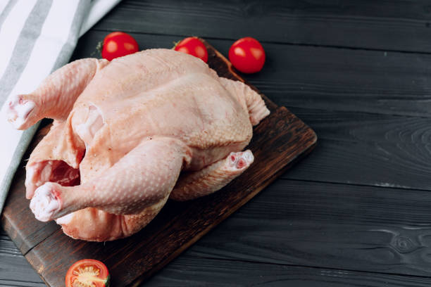 istock Raw whole chicken carcass on wooden cutting board 1303800420