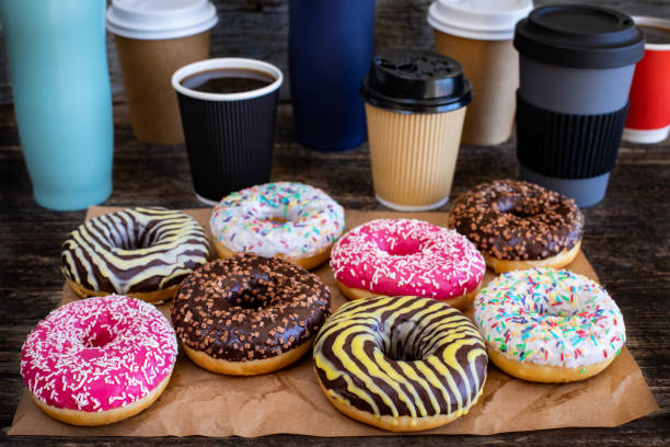 muitas rosquinhas coloridas na mesa com café filtro. - snack coffee instant coffee cappuccino - fotografias e filmes do acervo