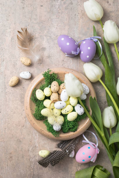 istock Easter composition with colorful Easter eggs and spring flowers  tulips on concrete background. Easter card  copy space 1303804020