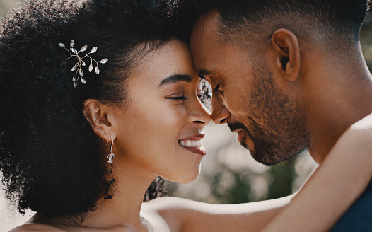 Cropped shot of a newlywed couple standing together and sharing an intimate moment after their wedding