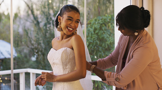 Cropped shot of a happy young bride bonding with her mother while she gets ready for her wedding