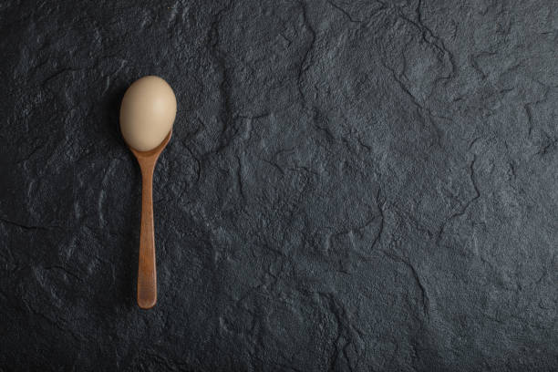 istock Single organic chicken egg on wooden spoon 1303804873
