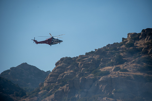 Chatsworth, California, United States - October 19, 2020: Firefighters and helicopters from LAFD, LACFD, and VCFD battle a brush fire in the hills West of Chatsworth in Los Angeles and Ventura County.
