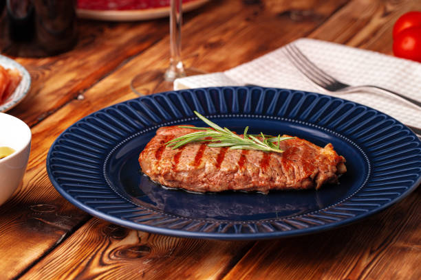 istock Grilled beef steak served on blue plate 1303807700