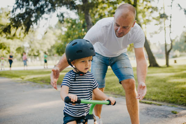 istock Little boy learning to ride a bicycle 1303808078