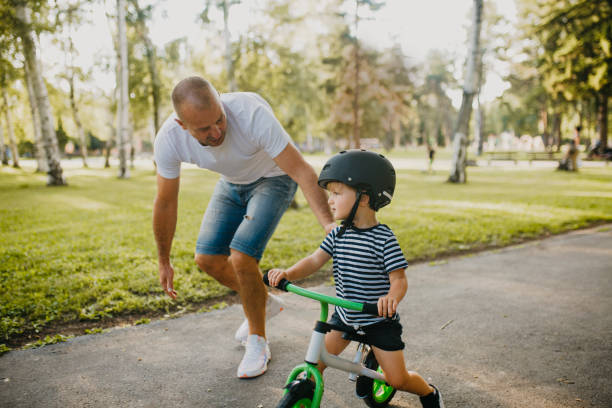 istock Little boy learning to ride a bicycle 1303808126