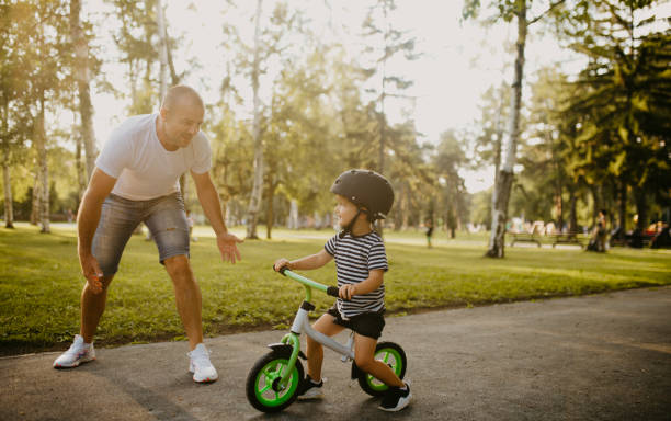 istock Little boy learning to ride a bicycle 1303808134