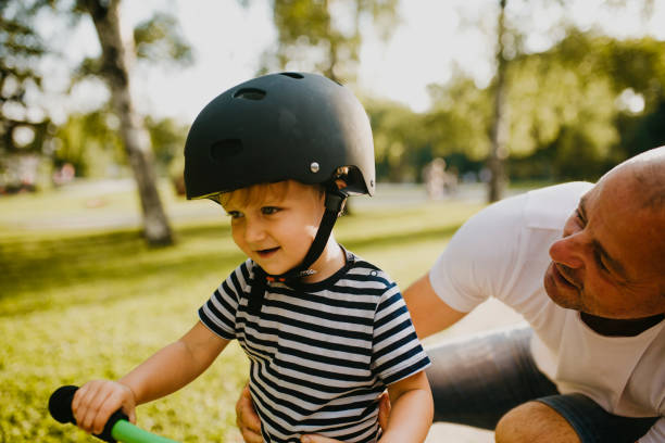 istock Little boy learning to ride a bicycle 1303808143