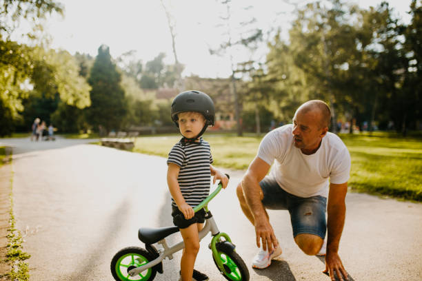 istock Little boy learning to ride a bicycle 1303808149