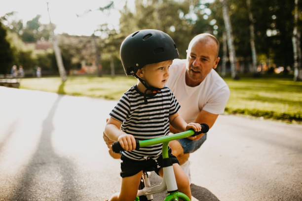 istock Little boy learning to ride a bicycle 1303808151