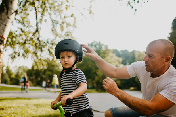 istock Little boy learning to ride a bicycle 1303808169