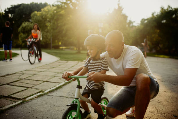istock Little boy learning to ride a bicycle 1303808292