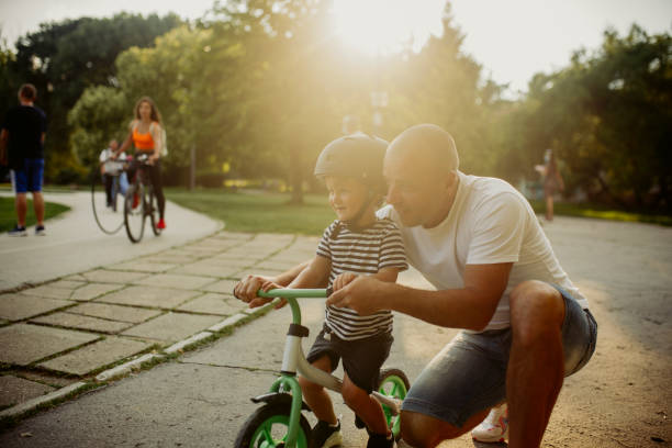 istock Little boy learning to ride a bicycle 1303808965