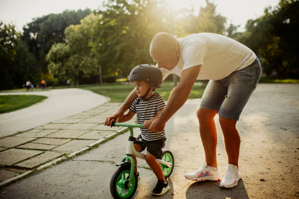 istock Little boy learning to ride a bicycle 1303808983