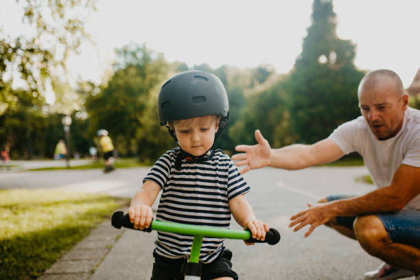 istock Little boy learning to ride a bicycle 1303809039