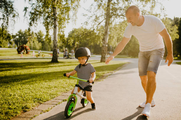 istock Little boy learning to ride a bicycle 1303809168
