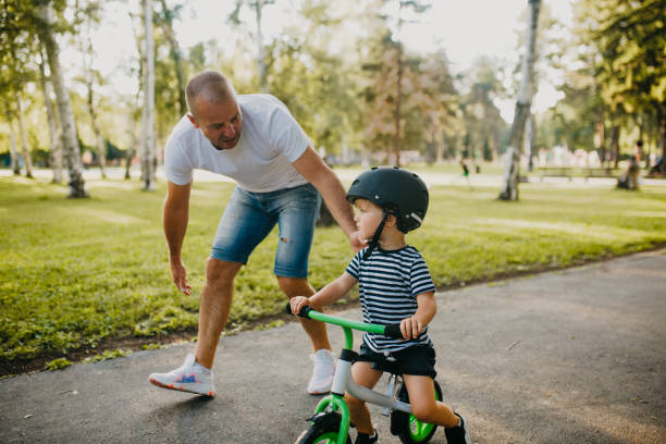 istock Little boy learning to ride a bicycle 1303809250