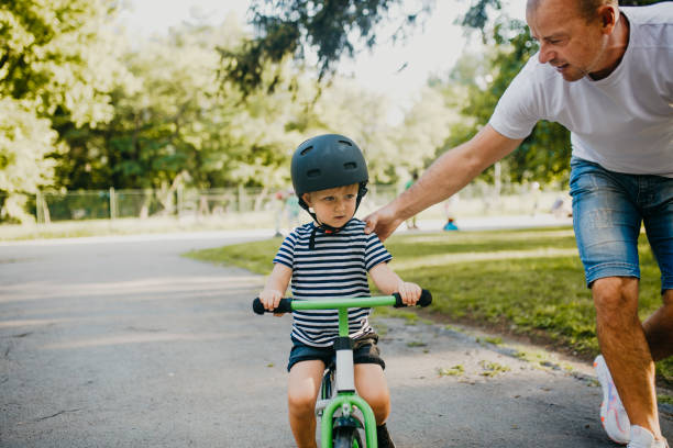 istock Little boy learning to ride a bicycle 1303809289